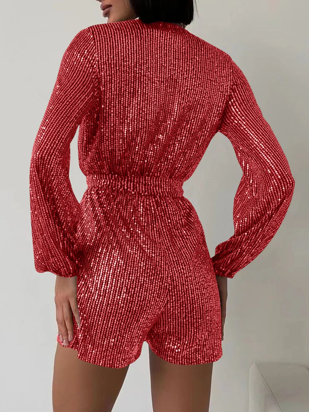 Dark green sequin long sleeve romper by Marigold Collections Australia, featuring a surplice neckline and tie waist, formal dress style.