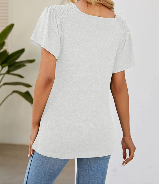 Marigold Collections Australia smocked shoulder flutter sleeve top, light fabric, and feminine design with ruffled sleeves.