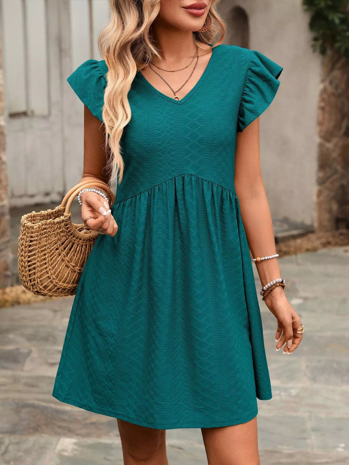 Marigold Collections Australia ruffle sleeve v-neck A-line mini dress hanging on a wooden hanger with floral backdrop.