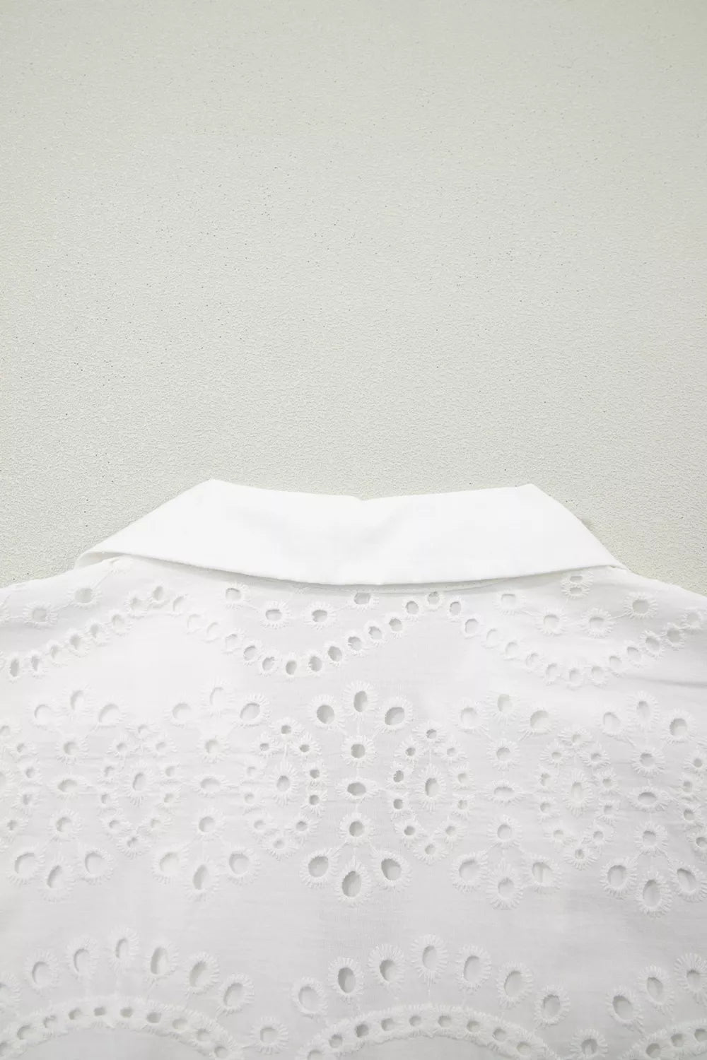 White eyelet collared mini dress by Marigold Collections Australia, featuring a fitted silhouette and button details.