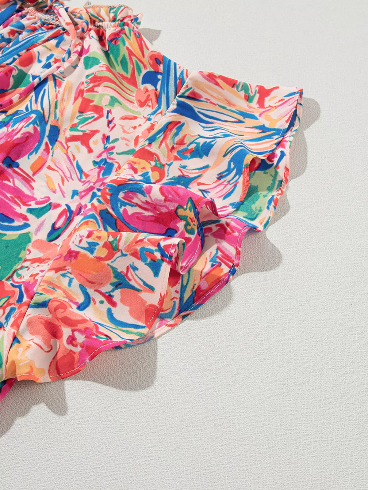Multicolour floral V-neck summer blouse with ruffled sleeves from Marigold Collections Australia, featuring a lightweight, flowy fabric.