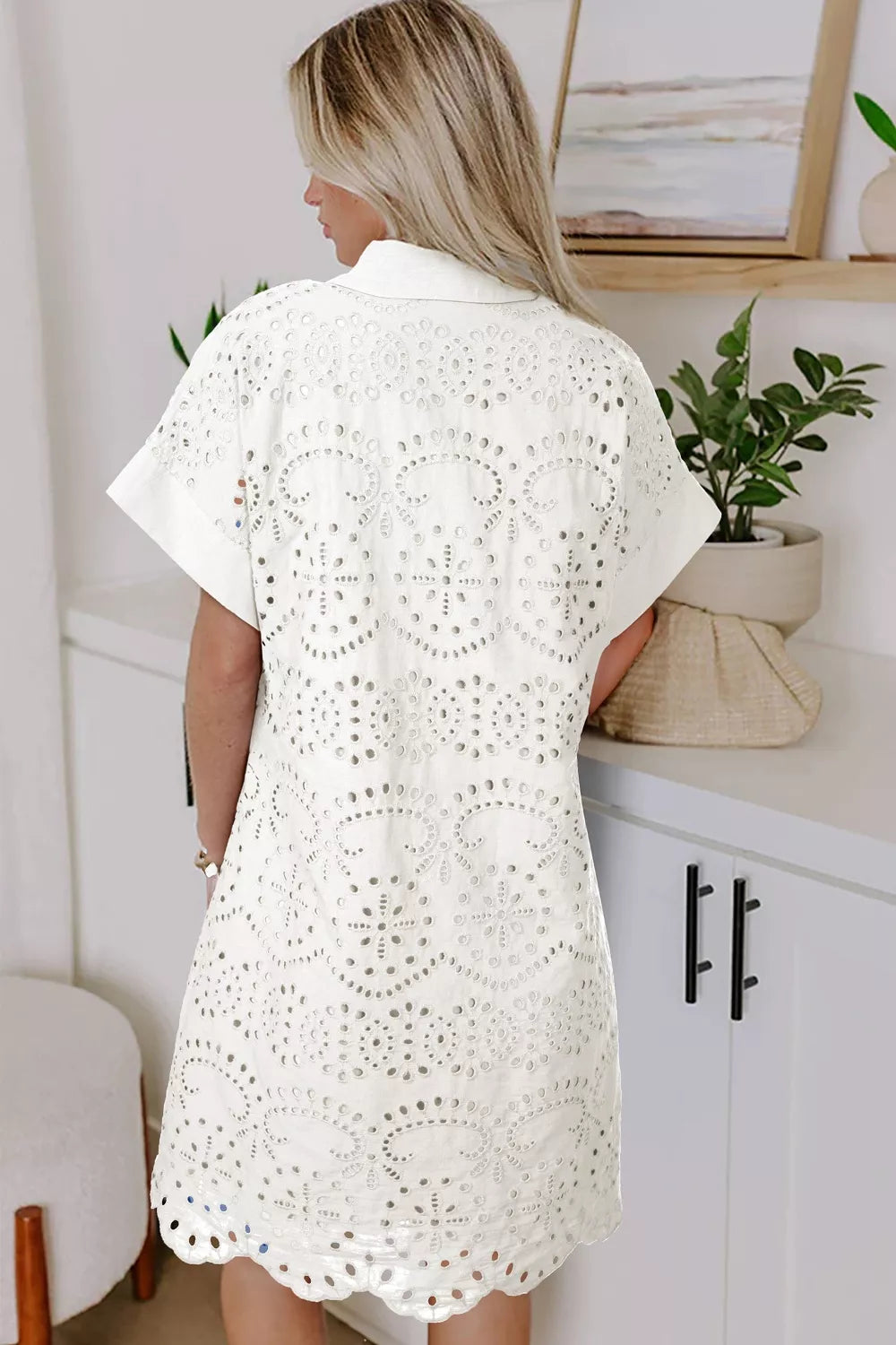 White eyelet collared mini dress by Marigold Collections Australia, featuring a fitted silhouette and ruffled hem.