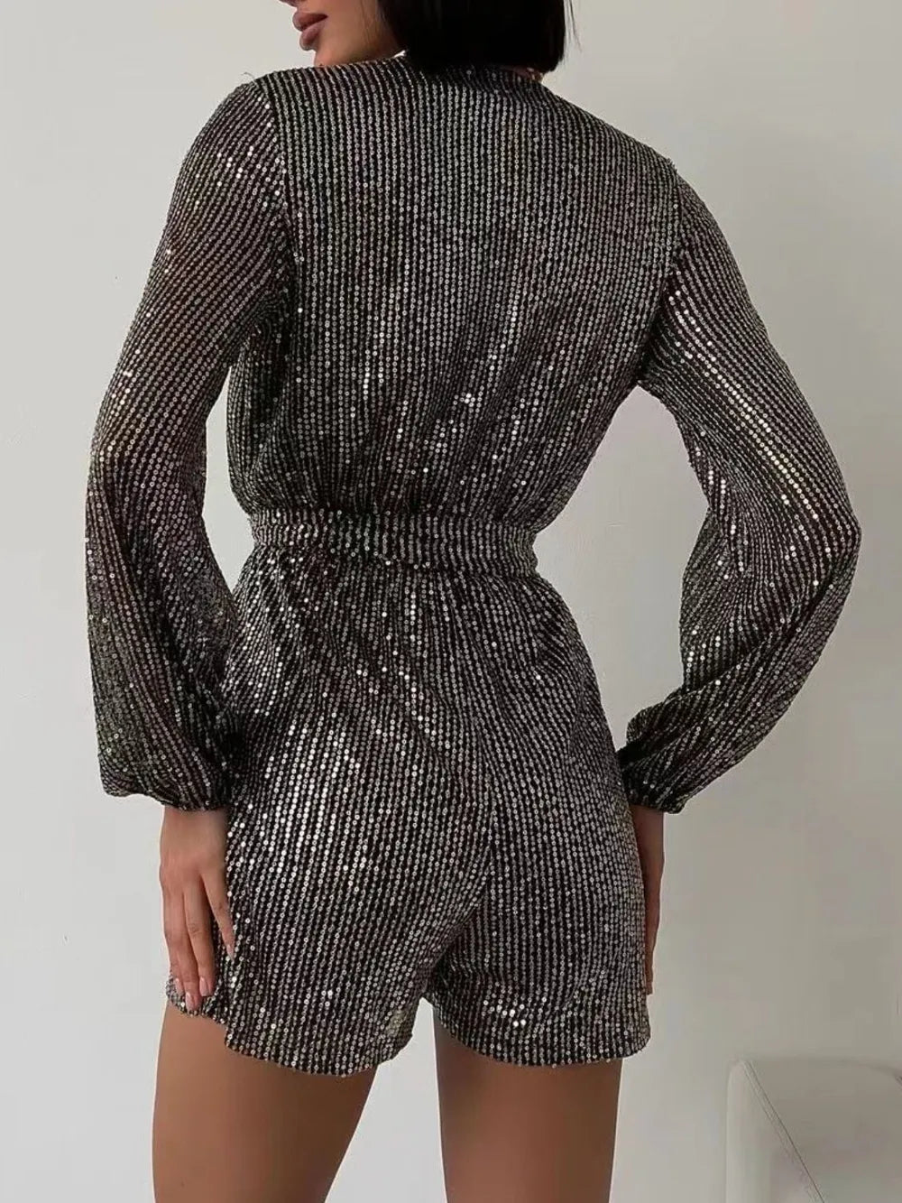 Dark green sequin long sleeve romper by Marigold Collections Australia, with surplice neckline and tie waist, ideal for formal evenings.