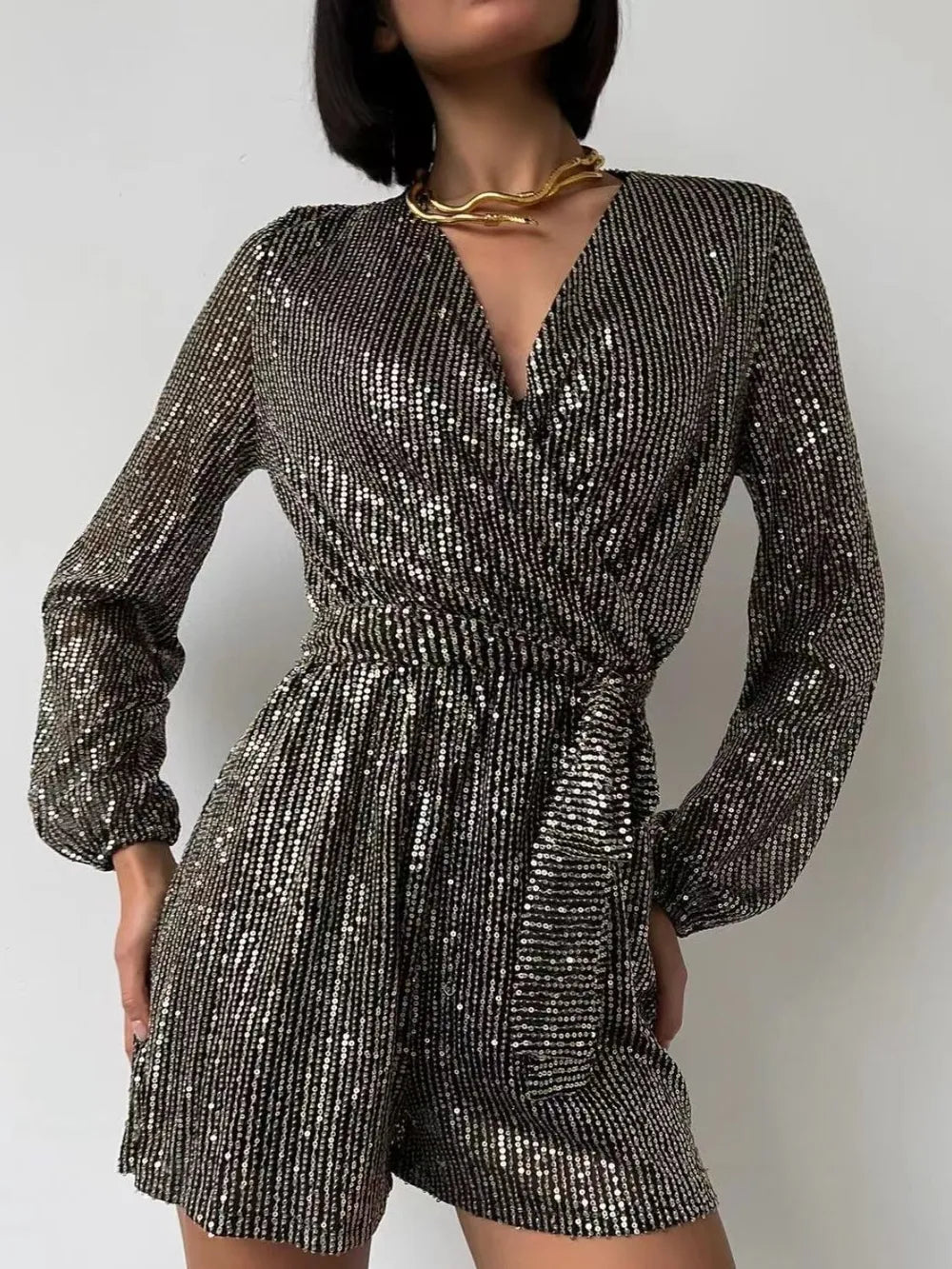 Dark green sequin long sleeve romper by Marigold Collections Australia, featuring a surplice neckline and tie waist for evening wear.