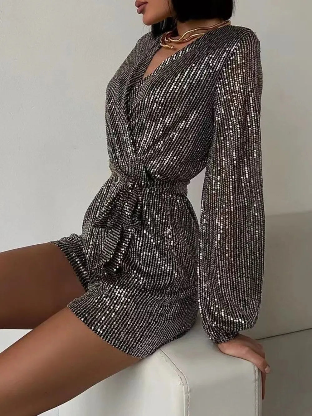 Dark green sequin long sleeve romper by Marigold Collections Australia featuring a surplice neckline and tie waist for evening wear.