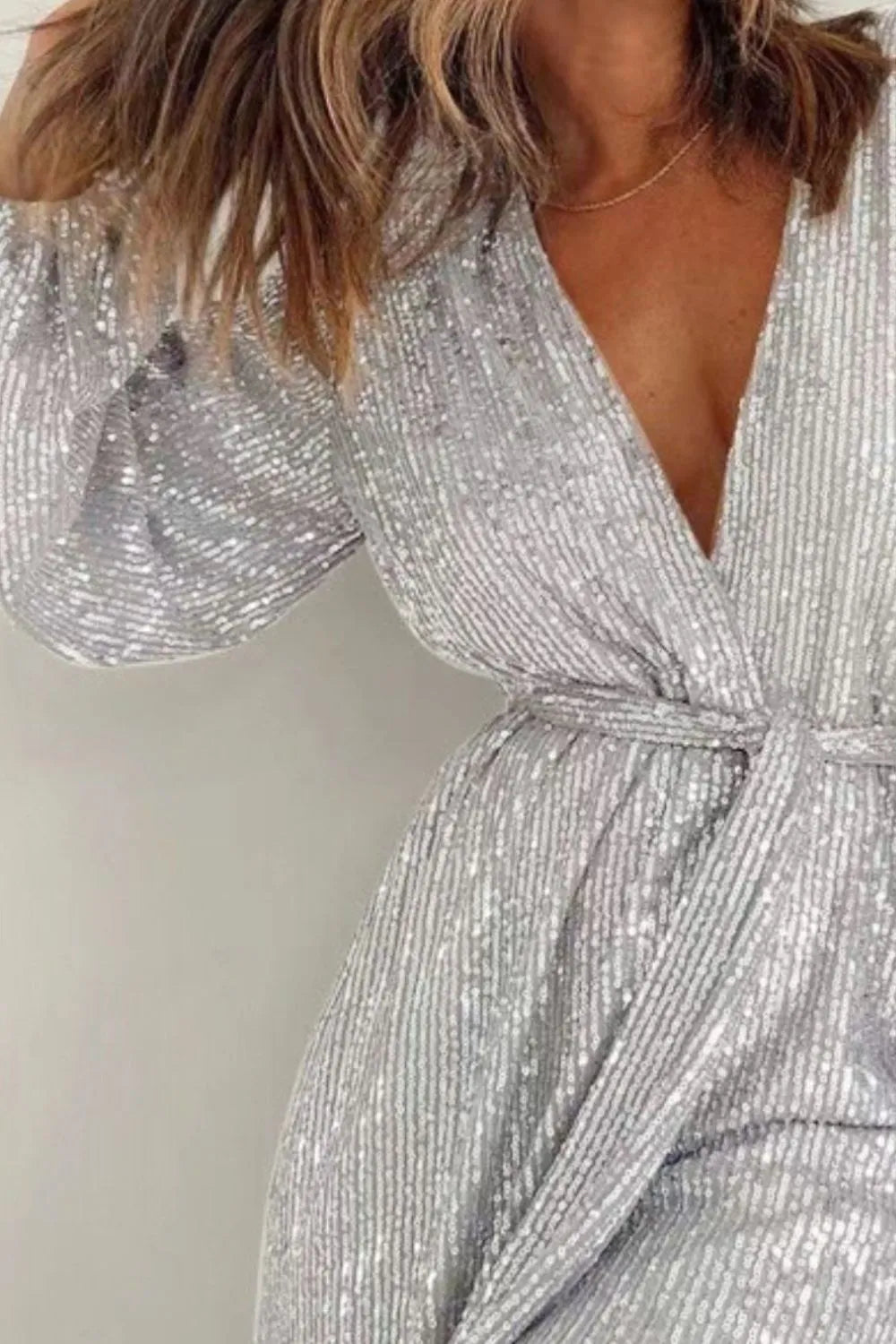Dark green sequin long sleeve romper by Marigold Collections, elegant women's jumpsuit with surplice neckline and tie waist.