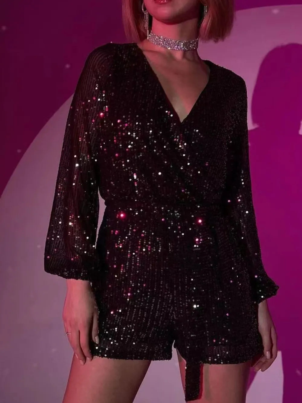 Dark green sequin long sleeve romper by Marigold Collections Australia, featuring a surplice neckline and tie waist for elegant evening wear.