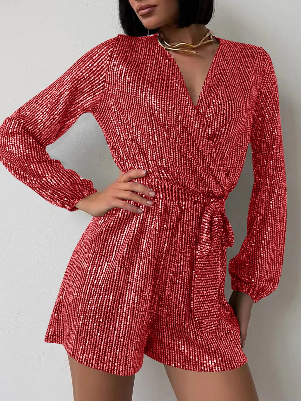 Dark green sequin long sleeve romper by Marigold Collections Australia, featuring a surplice neckline and tie waist for elegant evening wear.